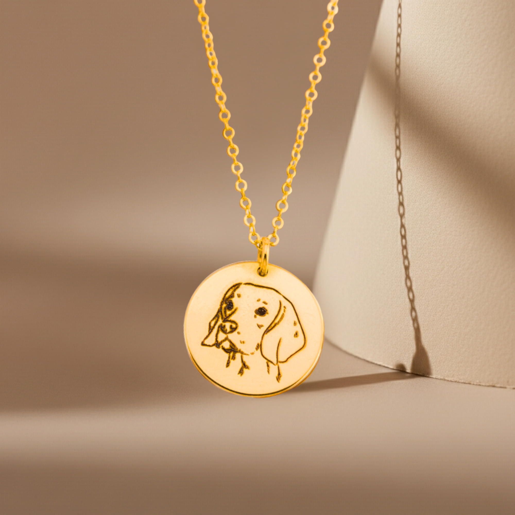 Gold necklace with a round pendant featuring a dog illustration on a beige background