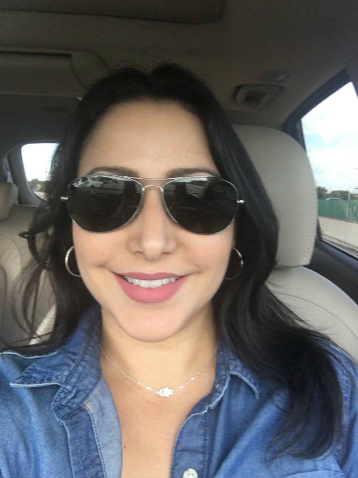 Women Similing & wearing Sideways Hamsa Necklace in Silver